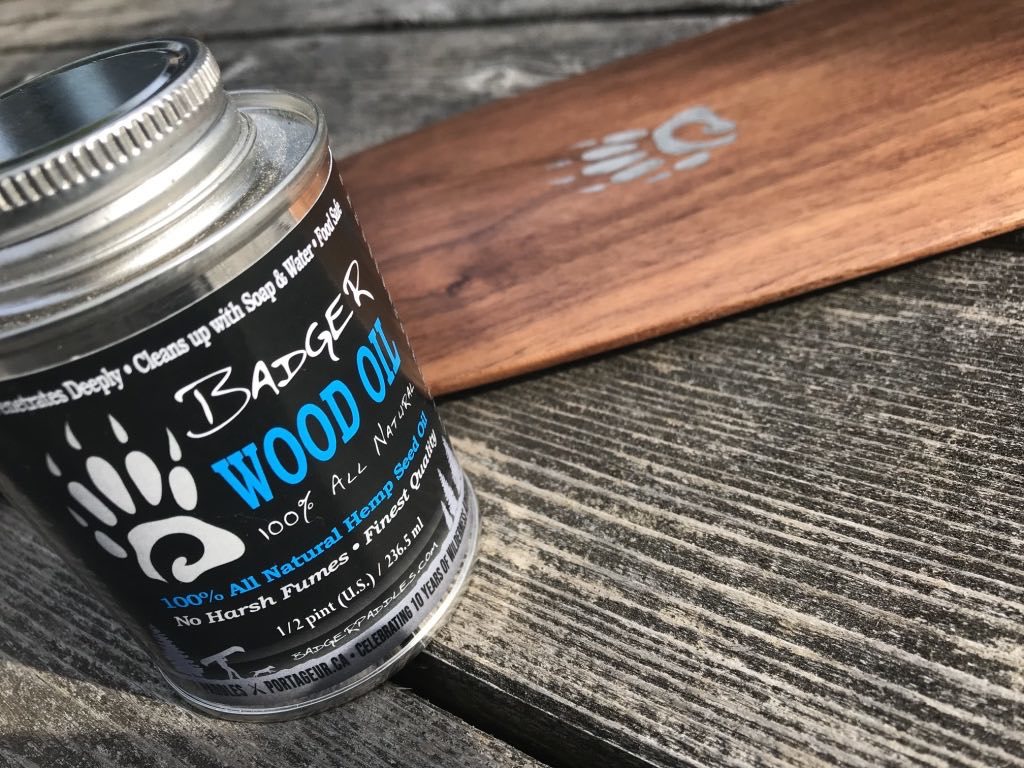 product shot of Badger Wood Oil 1/2 Pint tin with a walnut anniversary canoe paddle in background