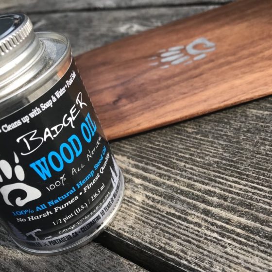 product shot of Badger Wood Oil 1/2 Pint tin with a walnut anniversary canoe paddle in background