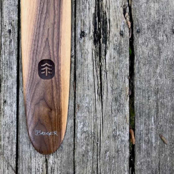 Special Edition Walnut Sliver Canoe Paddle on barn board background - blade TreeEra logo Badger text logo