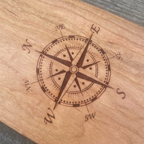 Detail of a MEDIUM sized laser engraved image of a nautical compass on a cherry wood canoe paddle
