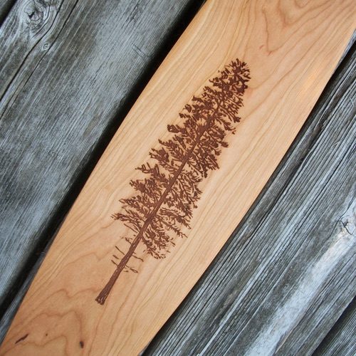 Detailed view of a Badger canoe paddle with an example of a LARGE custom laser engraved image of an illustrated tree encompassing most of the paddle blade