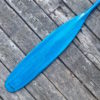 Detail of a vibrant blue tinted canoe paddle blade with a text logo that reads "Badger" - on a barn board background